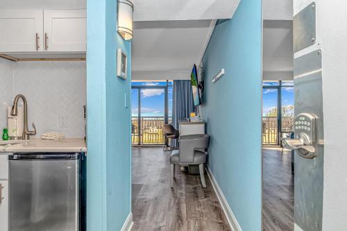 a kitchen with blue walls and a view of the city at Oceanfront Suite Grande Cayman 124 in Myrtle Beach
