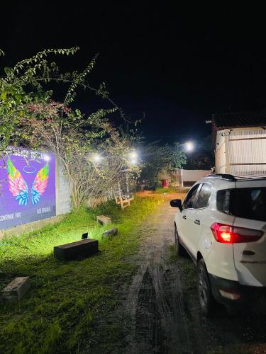 a white car parked on a dirt road at night at POUSADA CHARLOTTE in Tiradentes