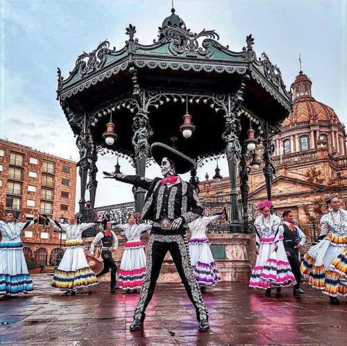 a group of people dancing in front of a gazebo at Tu joya y Tu Perla Tapatia - AC, alberca, Gym apartamento en el corazón de Guadalajara in Guadalajara