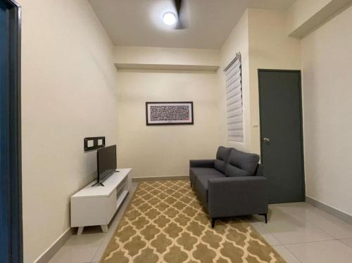 a living room with a couch and a chair and a table at Camellia Mesahill Homestay in Nilai