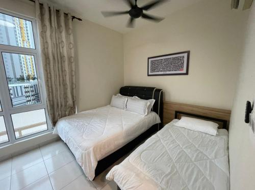 two beds in a room with a window at Camellia Mesahill Homestay in Nilai
