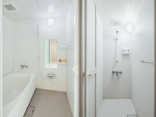 a white bathroom with a tub and a shower at HOTEL GRAPHY NEZU - Vacation STAY 82511 in Tokyo