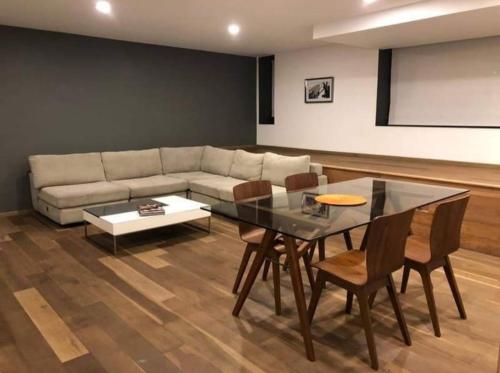 ein Wohnzimmer mit einer Couch und einem Tisch und Stühlen in der Unterkunft Estudio vacacional in Puerto Peñasco