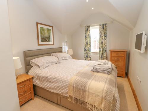 ein Schlafzimmer mit großem Bett und Fenster in der Unterkunft Rose Cottage in Penrith