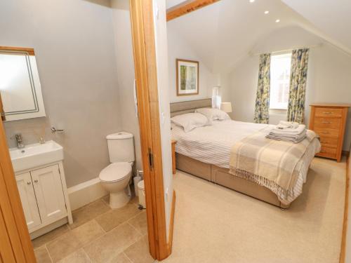 Schlafzimmer mit einem Bett, einem WC und einem Waschbecken in der Unterkunft Rose Cottage in Penrith