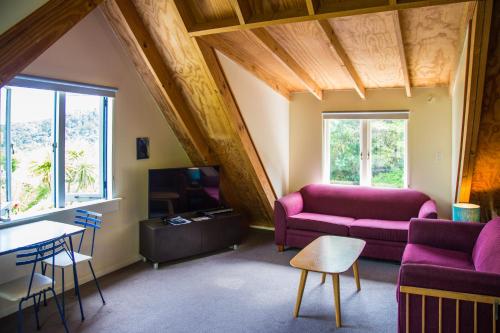 a living room with a couch and a tv at Fern Lodge Coromandel in Coromandel Town