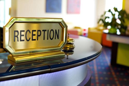 a gold reception sign on top of a table at Anusca Palace Hotel in Castel San Pietro Terme