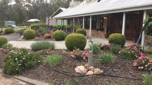 a garden in front of a building with flowers at Girraween Country Inn in Ballandean