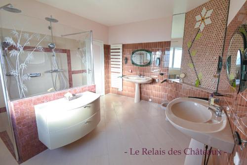 ein Badezimmer mit einer Badewanne, einem Waschbecken und einer Badewanne in der Unterkunft LE RELAIS DES CHATEAUX in Margaux