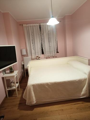 a bedroom with a white bed and a flat screen tv at Il Casale di Lavinia in Fabro