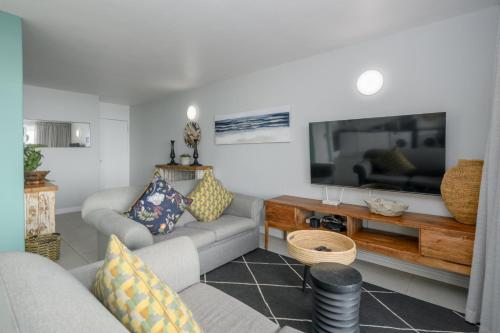 a living room with a couch and a tv at Chakas Cove in Ballito