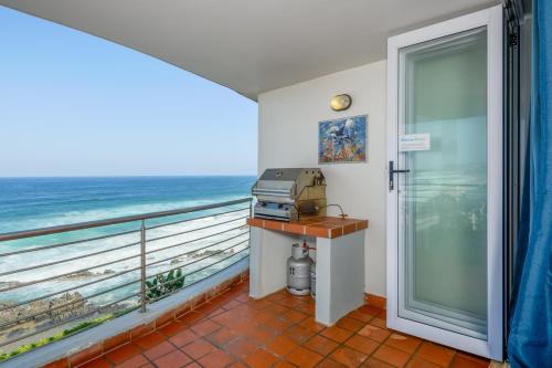 a room with a balcony with a view of the ocean at Chakas Cove in Ballito