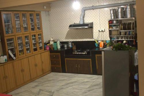 uma cozinha com armários de madeira e um balcão preto em BOJO House em Gangtok