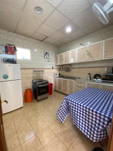 a kitchen with a table and a white refrigerator at روز الهدا in Al Hada