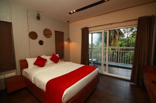 Un dormitorio con una cama con almohadas rojas y una ventana en Bonita Banasura, en Vythiri