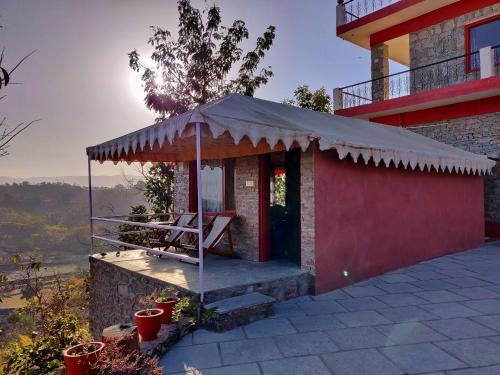 un edificio con porche con techo en The Sky Imperial Jungle Camp Resort, en Kumbhalgarh
