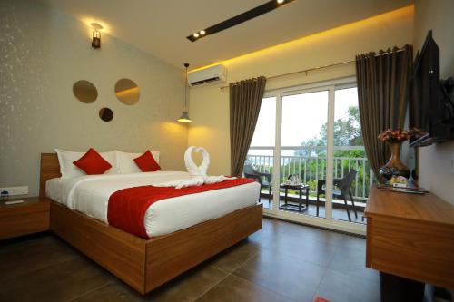 a bedroom with a bed and a balcony at Bonita Banasura in Vythiri