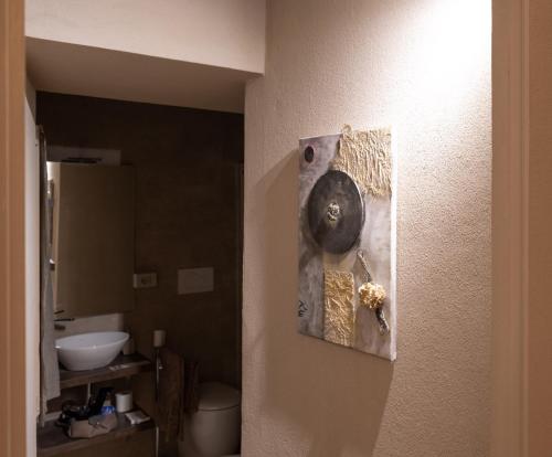 a bathroom with a picture hanging on the wall at Parma Centro House in Parma