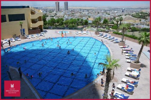 an overhead view of a large swimming pool with people in it at Grand Millennium Sulaimani in As Sulaymānīyah