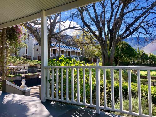 a porch with a white fence in front of a house at De Oude Pastorie in Swellendam