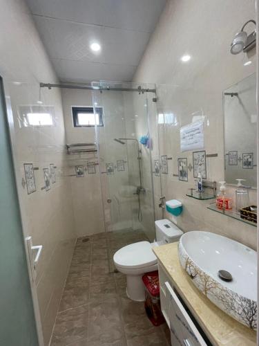 a bathroom with a shower and a toilet and a sink at Vy Ngọc Homestay in Khu Chi Lăng