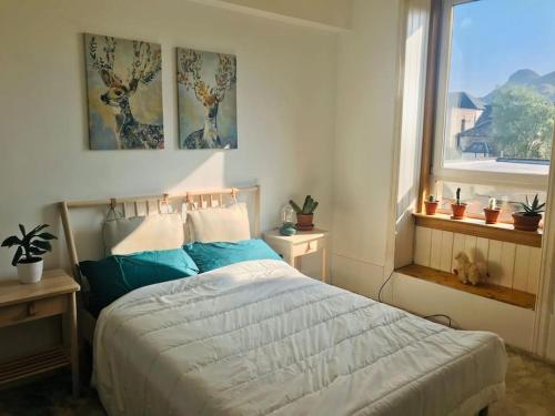 a bedroom with a bed with blue pillows and a window at Cosy 2 Bedroom Flat in Edinburgh in Edinburgh