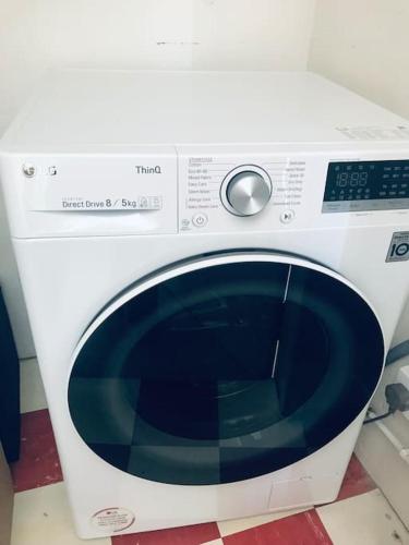 a white washing machine sitting on top of a counter at Cosy 2 Bedroom Flat in Edinburgh in Edinburgh