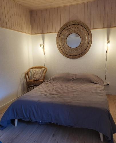 ein Schlafzimmer mit einem Bett, einem Spiegel und einem Stuhl in der Unterkunft Villa bord de mer avec belle terrasse in Port Leucate