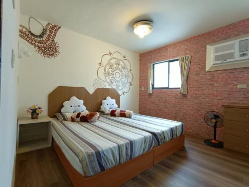 a bedroom with a bed with a brick wall at 博愛泊旅讀心境 in Hualien City