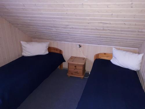 a room with two beds and a night stand at Marinapark Scharmützelsee in Wendisch Rietz
