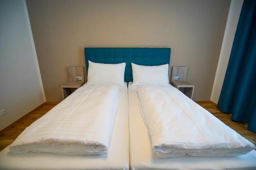 a pair of beds in a room with blue curtains at Sportpark Warmbad-Villach in Villach