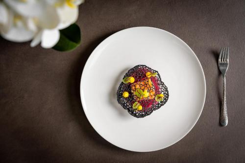 a cookie on a white plate next to a fork at Coast Hotel & Spa - Adults Only Aperto tutto l'anno in Milano Marittima