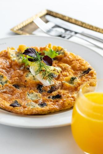a plate of food with a pizza on a table at Gerlóczy Boutique Hotel in Budapest