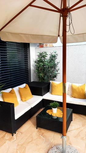 a living room with two couches and an umbrella at Nobless Apartments Holedná Brno in Brno