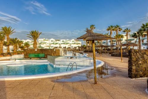 ein Resortpool mit einem Hotel im Hintergrund in der Unterkunft N E W 2021 My-Lanza the Luxury ONE in Costa Teguise