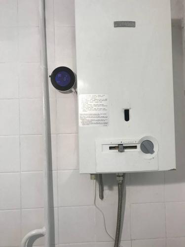a machine in a white tiled bathroom with aperature at Apartments near the Trinity Church on Dovzhenko Street,102 in Chernihiv