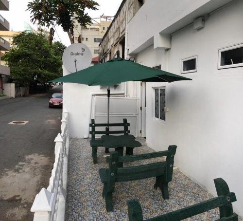 two benches sitting next to a building with an umbrella at WISH RESIDENCE SEASIDE Colombo3 in Colombo