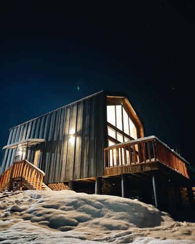 a wooden cabin in the snow at night at ЗаҐора in Tatariv
