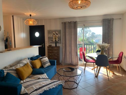 - un salon avec un canapé bleu et une table dans l'établissement Villa carioca appartement bâbord, à Gujan-Mestras