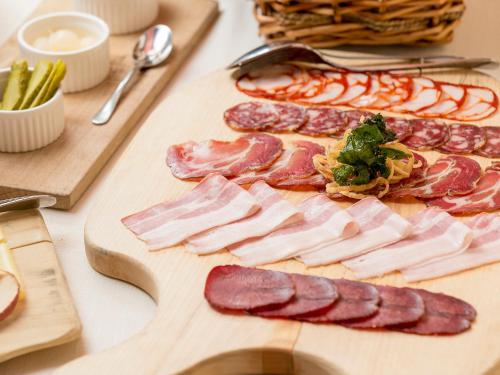 a bunch of meat on a cutting board on a table at Rooms & Restaurant Ostarija in Dolenjske Toplice