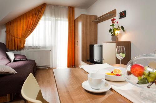 a living room with a table with a bowl of fruit at Rooms & Restaurant Ostarija in Dolenjske Toplice