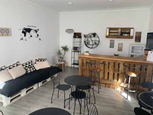 sala de estar con cama, mesa y sillas en Aloha Hostel en Portimão