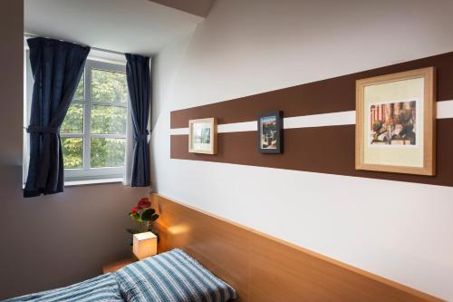 a bedroom with brown and white walls and a window at Rooms & Restaurant Ostarija in Dolenjske Toplice