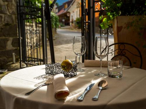 a table with a white table cloth and wine glasses at Rooms & Restaurant Ostarija in Dolenjske Toplice