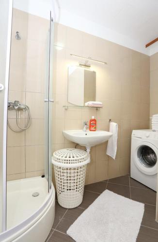 a bathroom with a sink toilet and a shower at Apartments Andelic in Vinišće