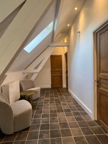 a attic room with two chairs and a staircase at Le Moulin de L'Abbaye Notre Dame du Vivier in Namur