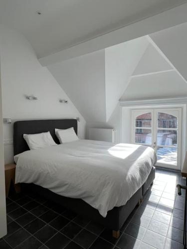 a white bed in a room with a window at Le Moulin de L'Abbaye Notre Dame du Vivier in Namur