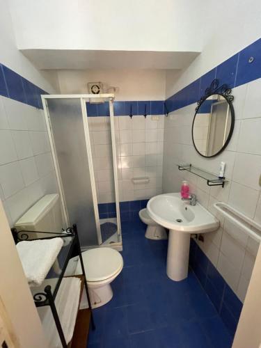 un bagno blu e bianco con lavandino e servizi igienici di Casa Salvatore a Messina