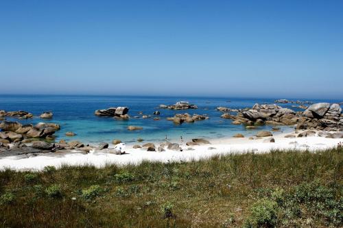 a beach with a bunch of rocks in the water at Keryerna Ar C'haouled "aux Hortensias" 3 clévacance in Saint-Méen