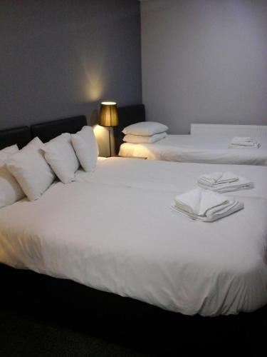 two beds in a hotel room with towels on them at The Liverpool Inn Hotel in Liverpool